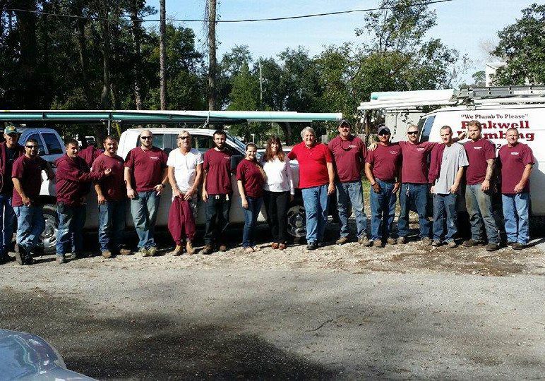 Rinkwell Plumbing team standing together with service trucks in Jacksonville Florida